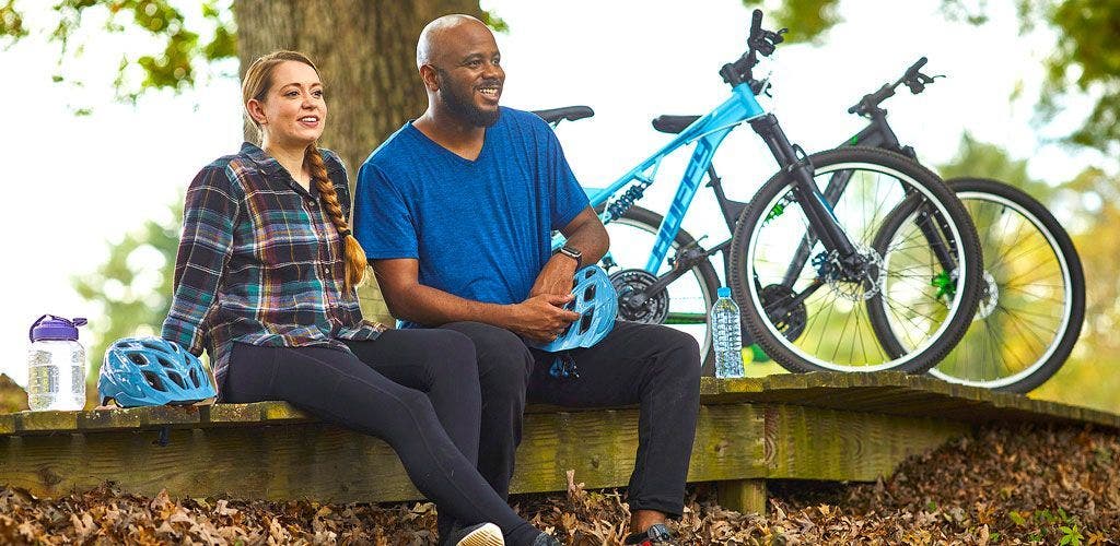 Couple resting with water by Huffy bikes