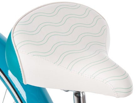 Close-up of a wide, padded bike saddle with wave patterns, highlighting comfort and stylish design.