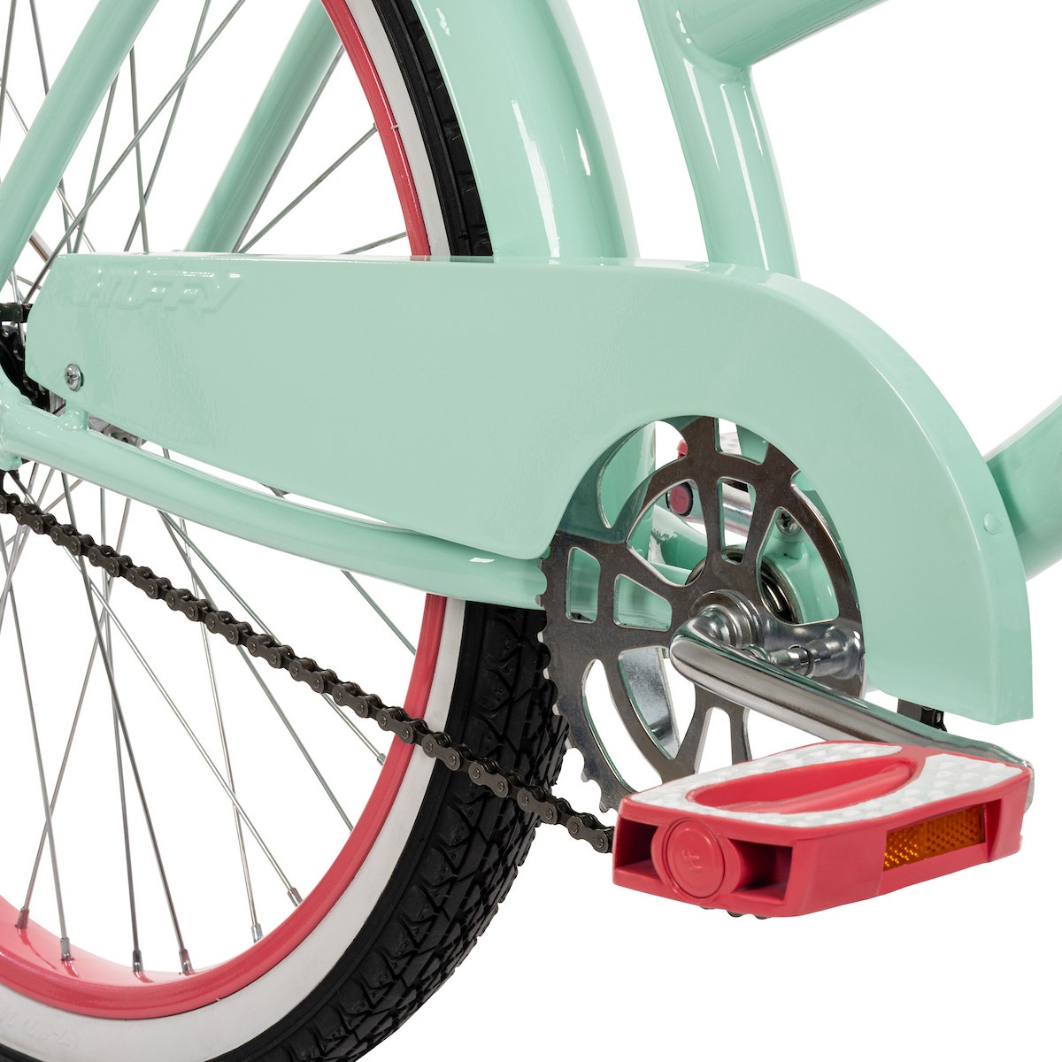 Close-up of a mint green cruiser bike’s chain and pedal area, featuring a matching full chainguard and colorful tire rim accents. Close-up of a mint green cruiser bike’s chain and pedal area, featuring a matching full chainguard and colorful tire rim accents.