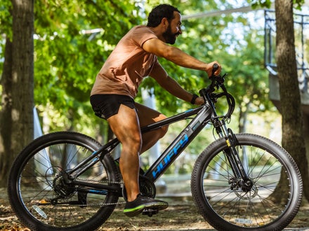 Man riding a Huffy Eventis e-bike on a forest trail, showcasing its sleek design and advanced pedal assist system for smooth outdoor riding. Man riding a Huffy Eventis e-bike on a forest trail, showcasing its sleek design and advanced pedal assist system for smooth outdoor riding.